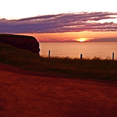 The sunset only highlights the red clay of the road. 