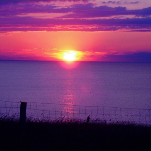 A red, yellow, orange and purple sunset over the water at Cape Tryon. 