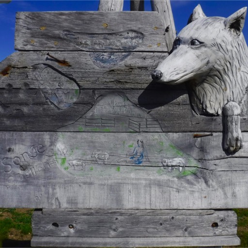 Stylized sculpture of a fox looking around the corner of a building. 